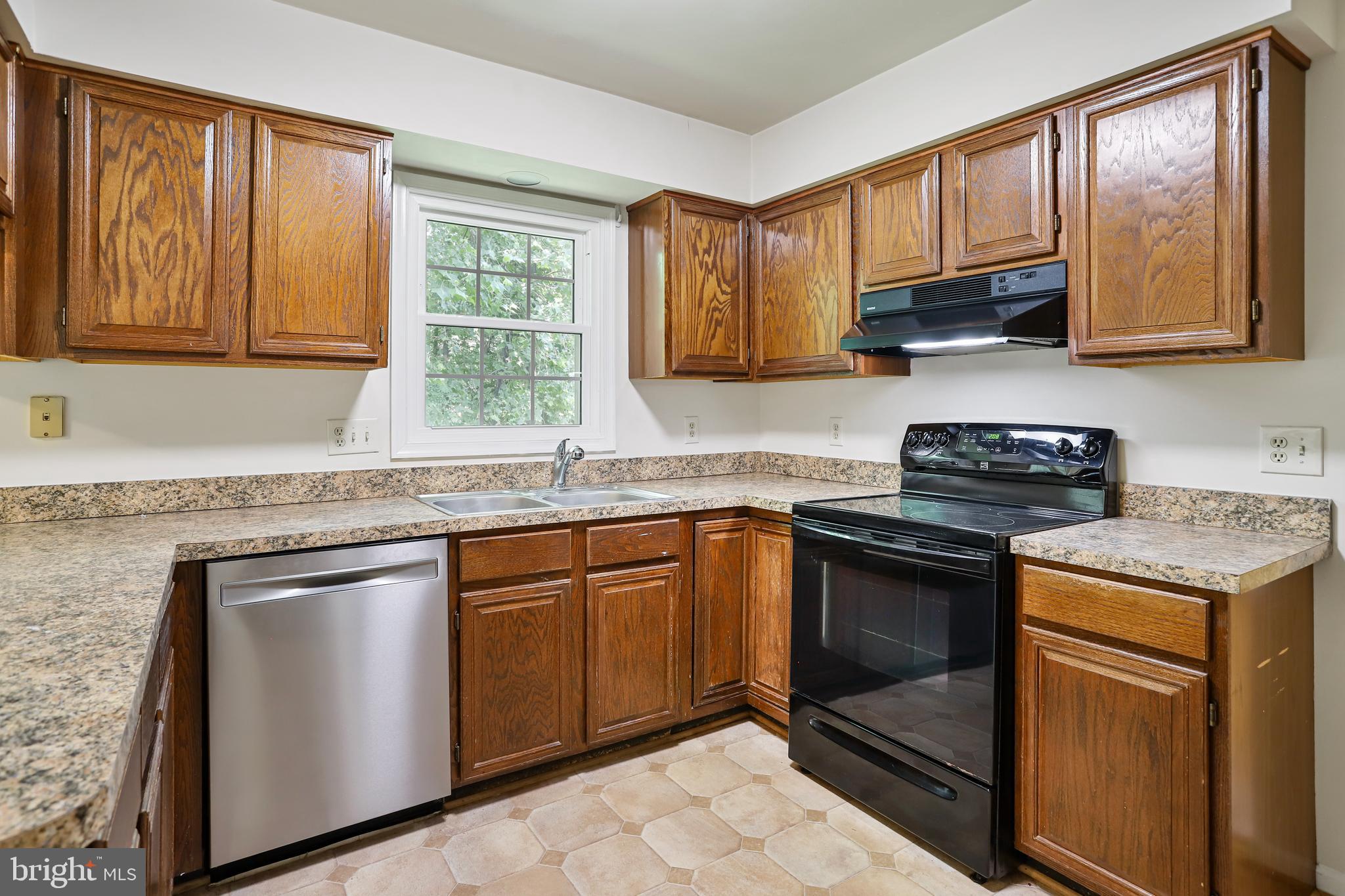 15108 Plum Tree Way Bowie, MD 20721 - Photo 11 of 51 a kitchen with granite countertop a stove sink and cabinets