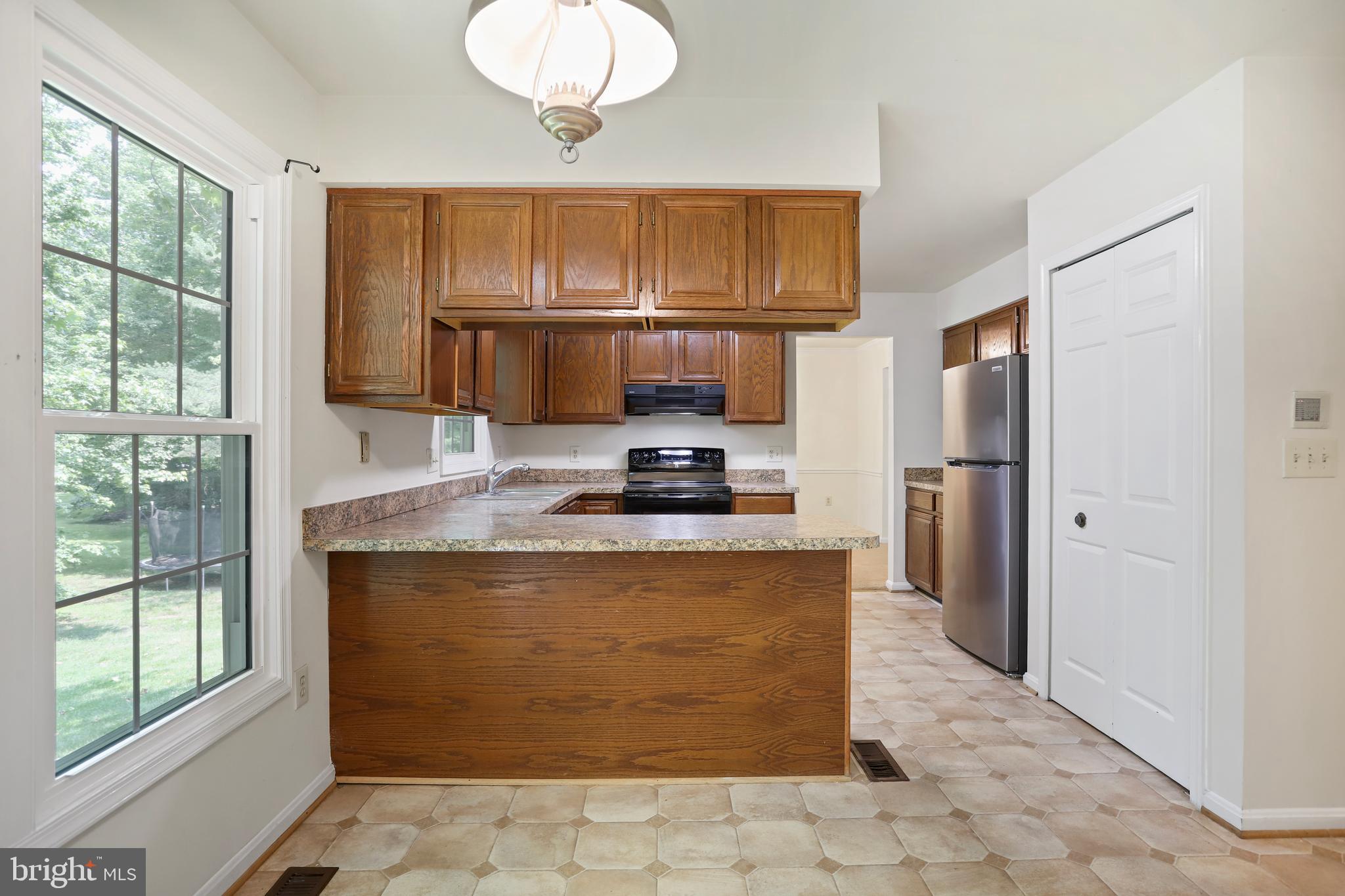 15108 Plum Tree Way Bowie, MD 20721 - Photo 13 of 51 a kitchen with kitchen island granite countertop a stove top oven a sink a counter top space and cabinets