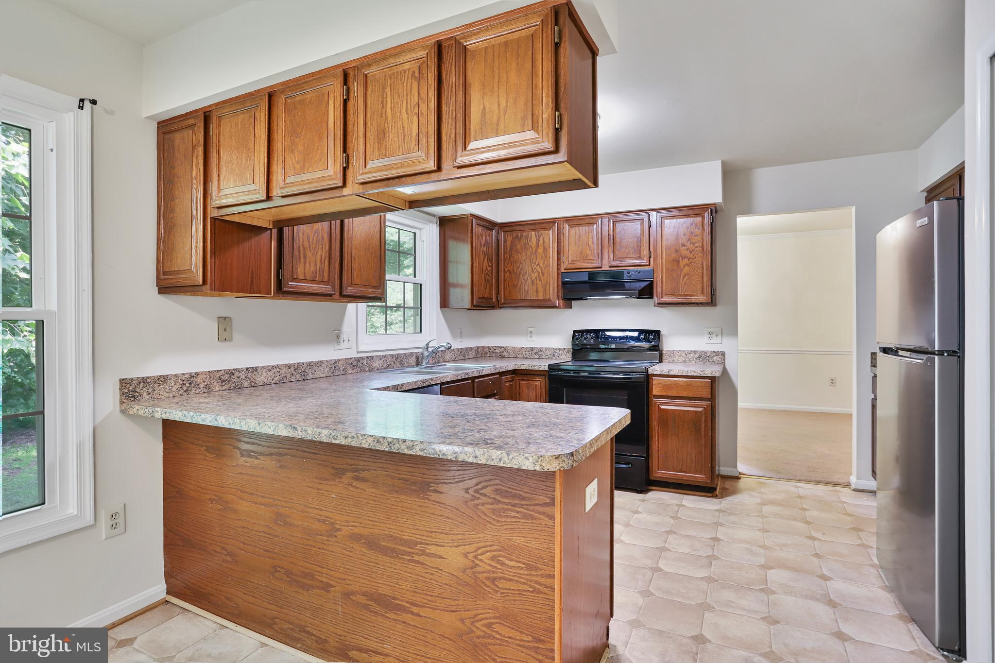 15108 Plum Tree Way Bowie, MD 20721 - Photo 9 of 51 a kitchen with granite countertop a refrigerator stove top oven and sink