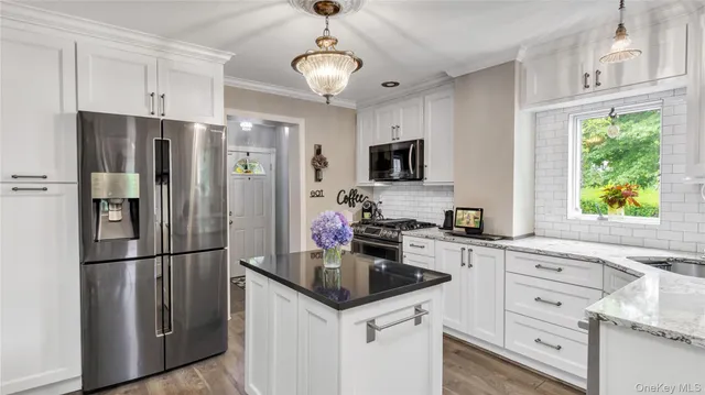 a kitchen with stainless steel appliances a stove a sink and a microwave