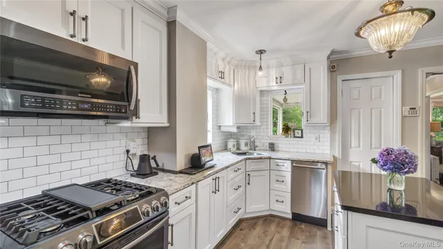 a kitchen with granite countertop a sink stainless steel appliances and cabinets