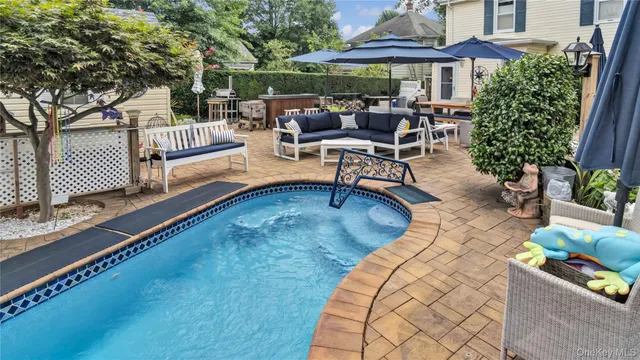 a view of a patio with couches table and chairs under an umbrella
