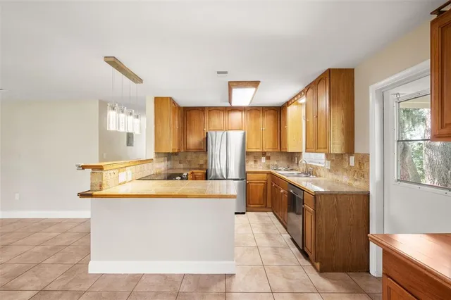 a large kitchen with kitchen island a sink counter top space and stainless steel appliances