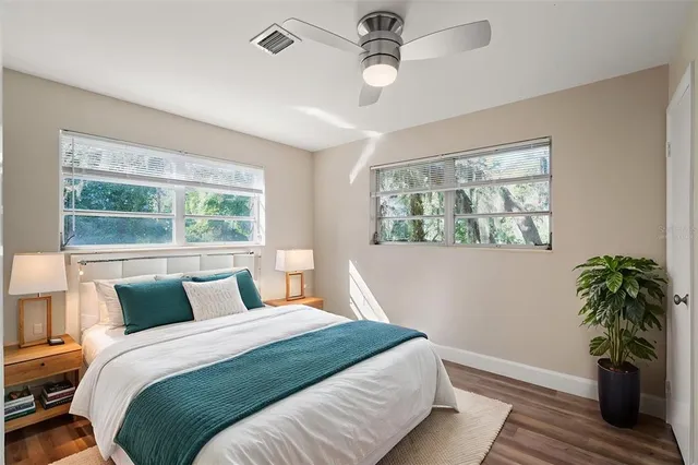 a bedroom with a large bed and a potted plant