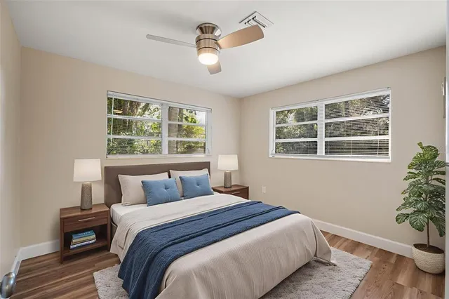 a bedroom with a large bed and a potted plant
