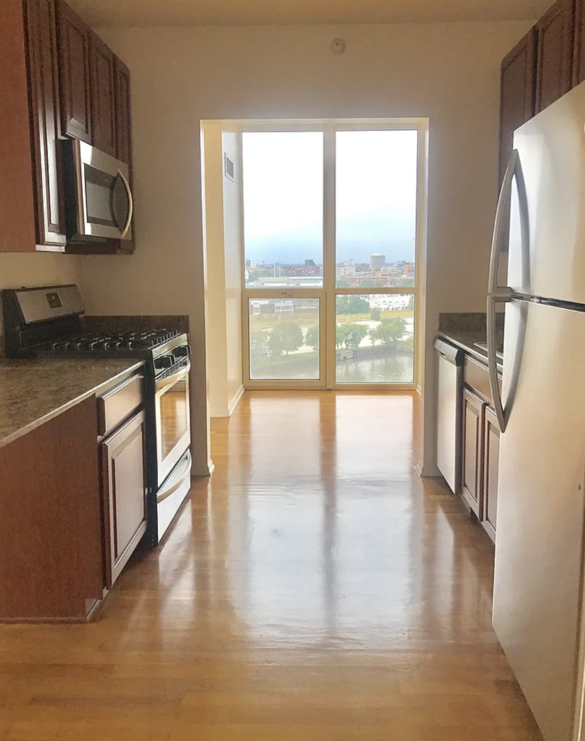 645 North Kingsbury Street, Unit 1002 Chicago, IL 60654 - Photo 6 of 11 a kitchen with stainless steel appliances granite countertop a refrigerator a stove and a large window