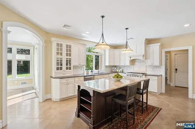 a kitchen with kitchen island a dining table chairs and a wooden floor
