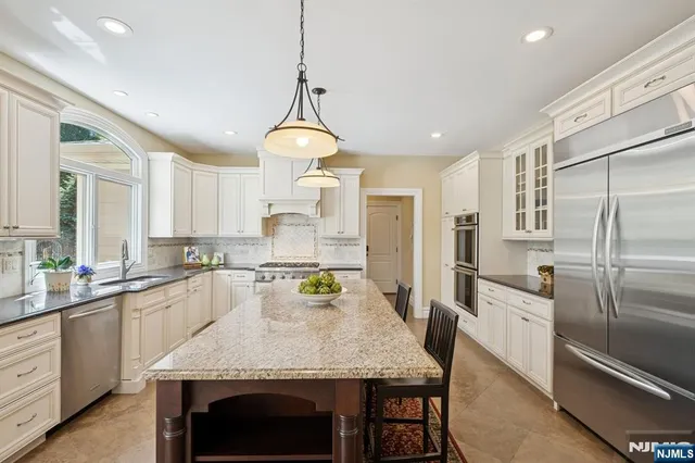 a kitchen with granite countertop a center island and stainless steel appliances