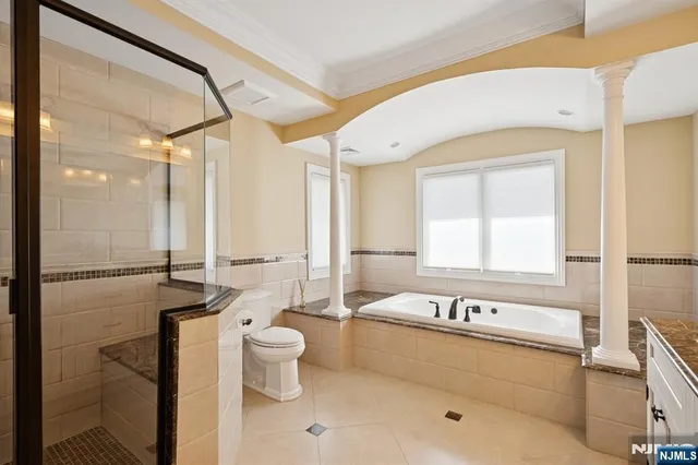 a bathroom with a granite countertop sink mirror bathtub and toilet