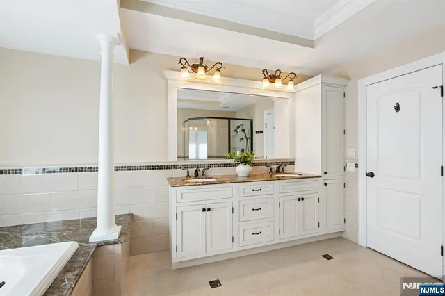 a bathroom with a tub sink and mirror
