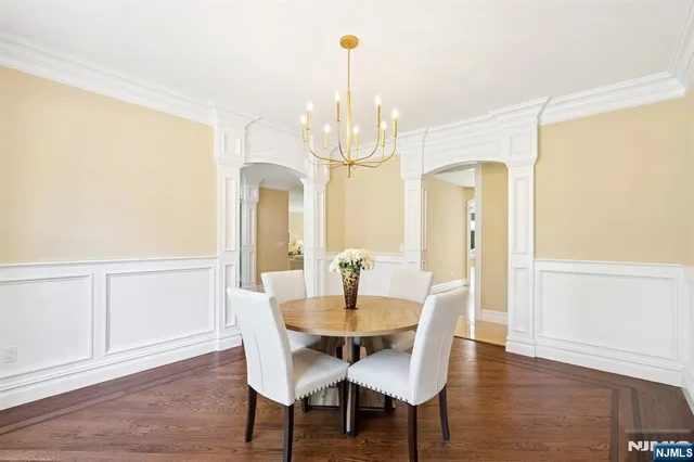 a dining room with furniture a chandelier and wooden floor