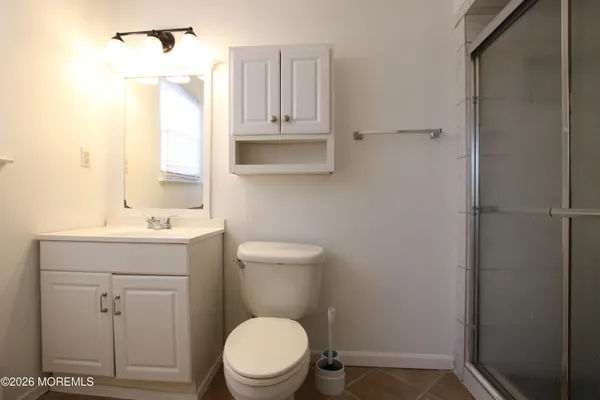 a bathroom with a toilet a sink a vanity and mirror