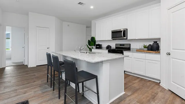 a kitchen with a dining table chairs and white appliances