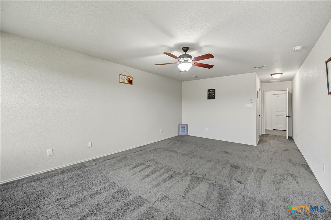 2411 Settlement Road Copperas Cove, TX 76522 - Photo 12 of 38 an empty room with a ceiling fan and a rug