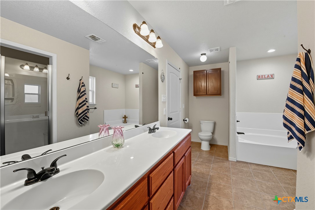 2411 Settlement Road Copperas Cove, TX 76522 - Photo 14 of 38 a bathroom with a sink a tub and mirror