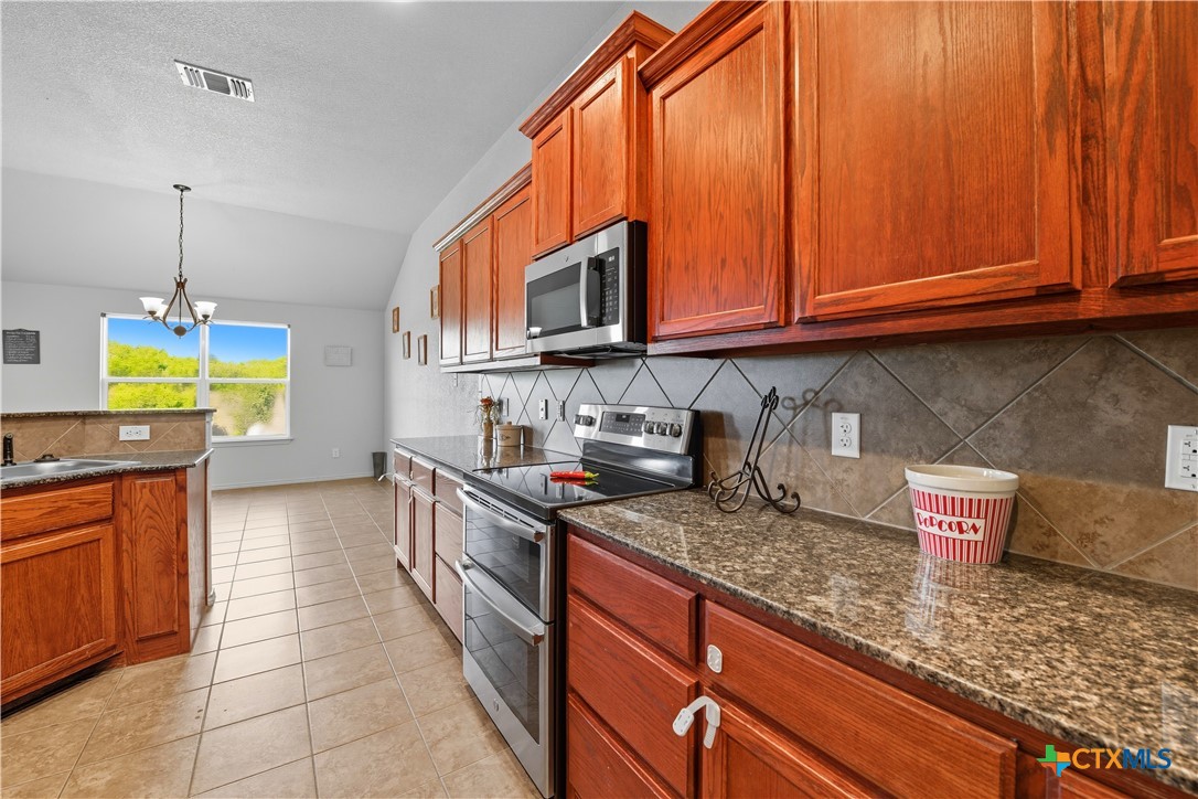 2411 Settlement Road Copperas Cove, TX 76522 - Photo 7 of 38 a kitchen with stainless steel appliances granite countertop a sink stove and cabinets