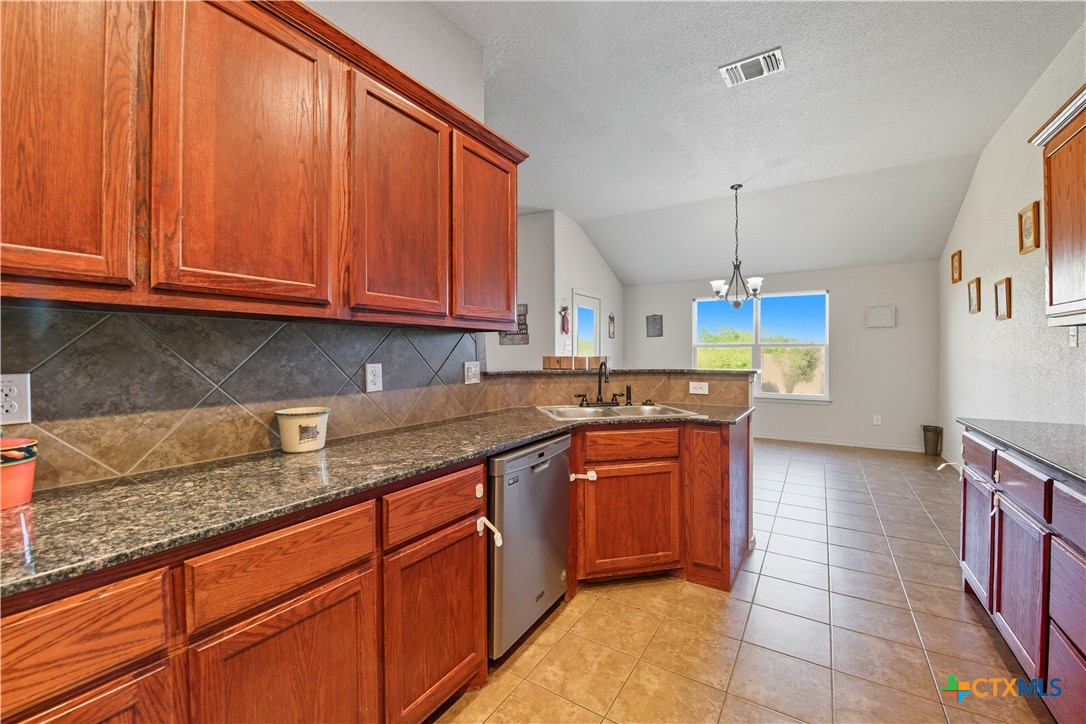 2411 Settlement Road Copperas Cove, TX 76522 - Photo 8 of 38 a kitchen with kitchen island granite countertop a sink stainless steel appliances and cabinets