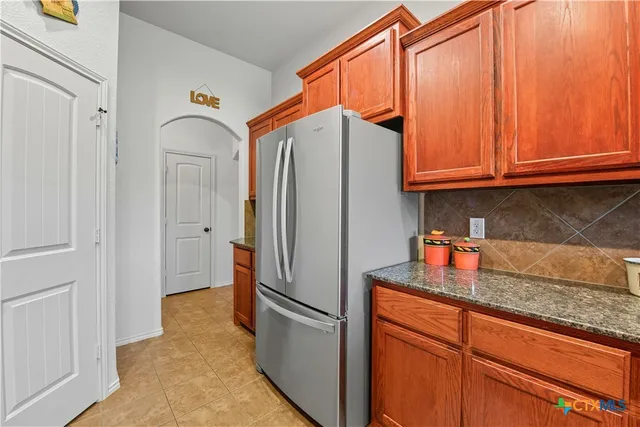 a kitchen with stainless steel appliances granite countertop a refrigerator and a sink