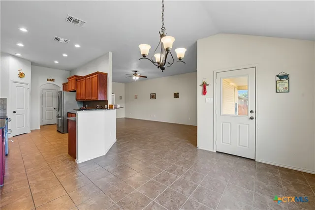 an empty room with a ceiling fan and a rug