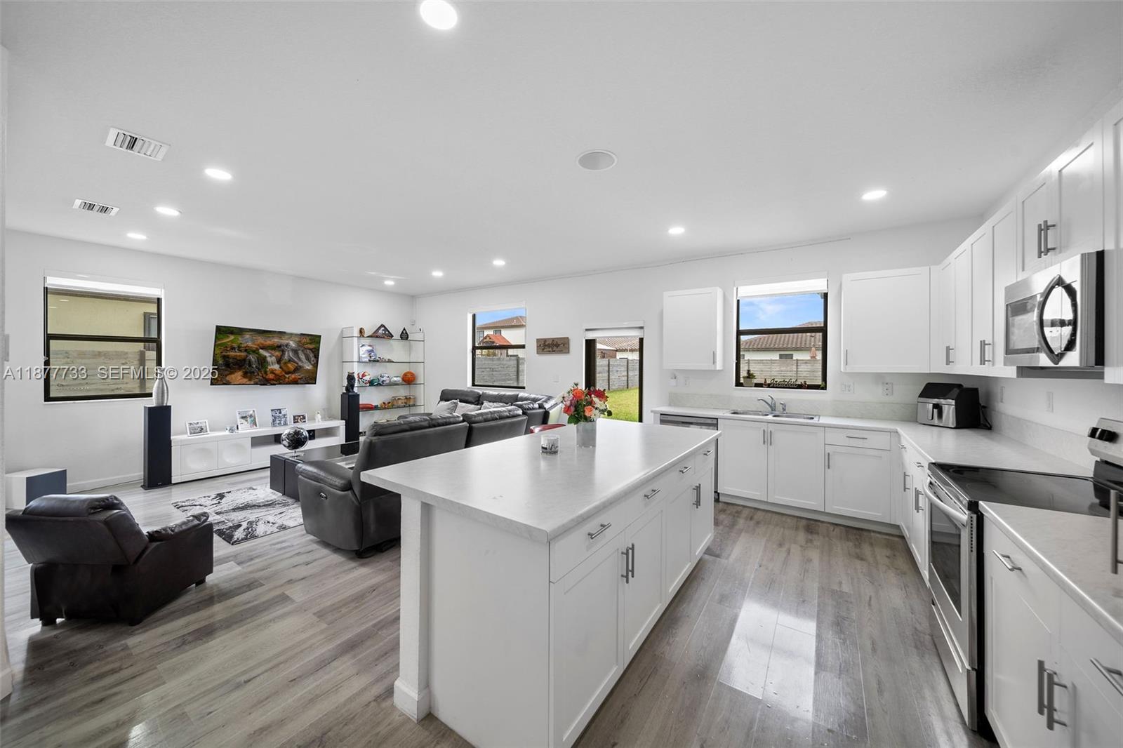 12833 Southwest 229th Terrace Miami, FL 33170 - Photo 13 of 43 a large white kitchen with a large window and stainless steel appliances