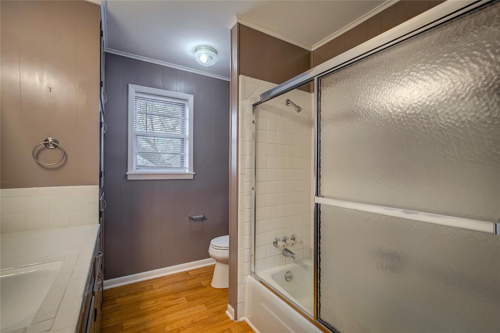 1004 Pecan Avenue Wills Point, TX 75169 - Photo 18 of 21 a bathroom with a granite countertop sink a toilet and shower