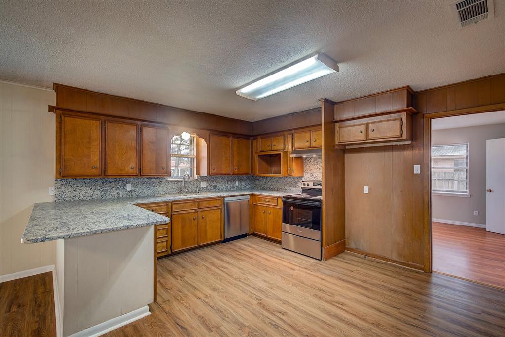 1004 Pecan Avenue Wills Point, TX 75169 - Photo 8 of 21 a kitchen with stainless steel appliances granite countertop a sink cabinets and wooden floor