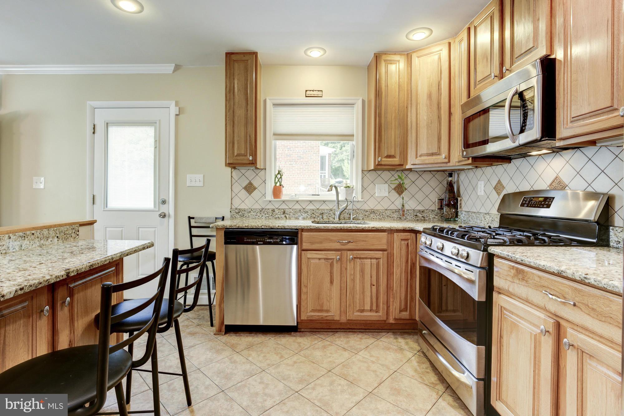 1305 Oakview Drive Silver Spring, MD 20903 - Photo 7 of 26 a kitchen with stainless steel appliances granite countertop a stove a sink and a microwave