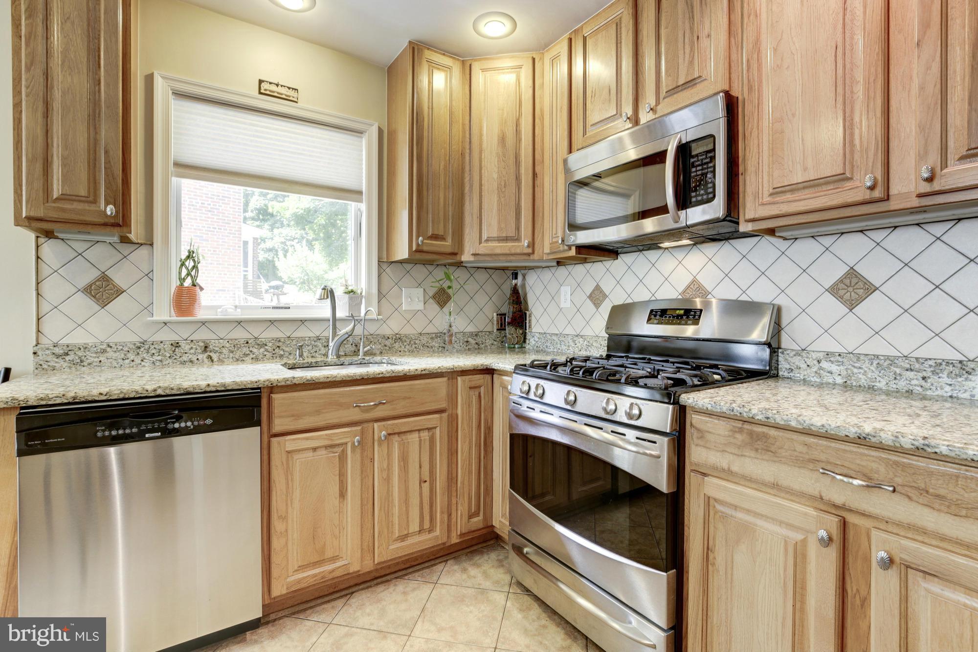 1305 Oakview Drive Silver Spring, MD 20903 - Photo 8 of 26 a kitchen with granite countertop white cabinets and a stove top oven