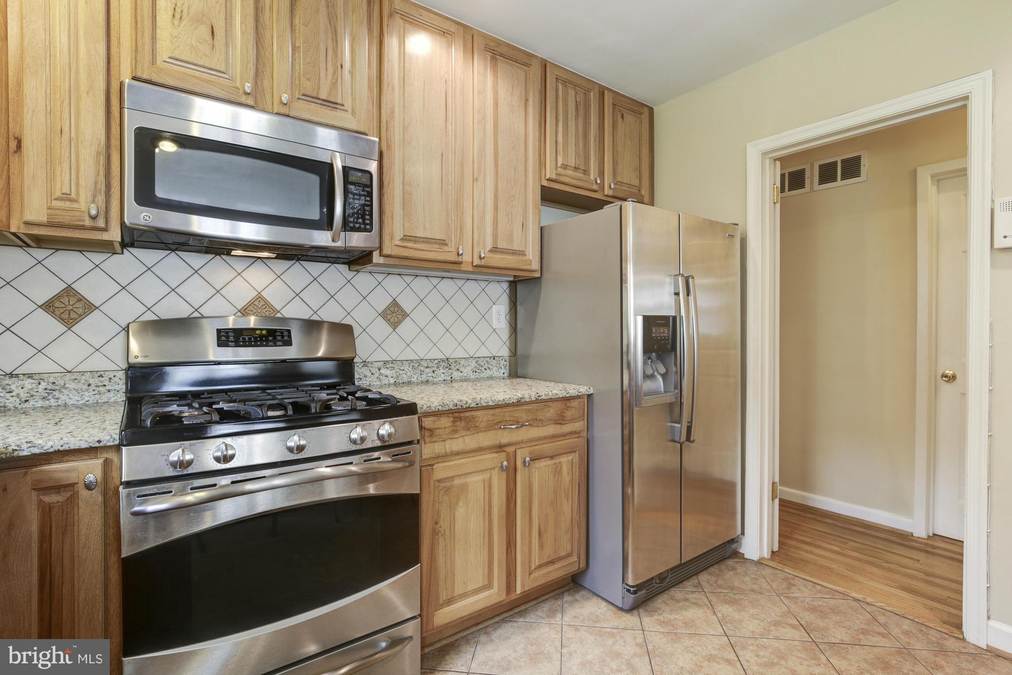 1305 Oakview Drive Silver Spring, MD 20903 - Photo 10 of 26 a kitchen with granite countertop a stove microwave and refrigerator