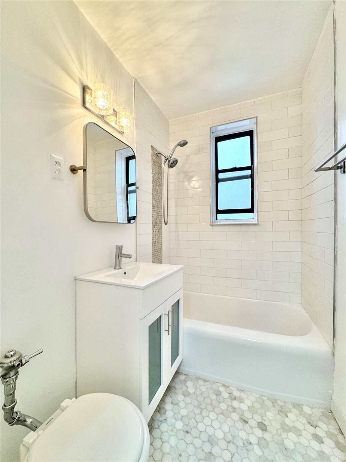 84-19 51st Avenue, Unit 4E Queens, NY 11373 - Photo 4 of 7 a bathroom with a granite countertop toilet sink and mirror