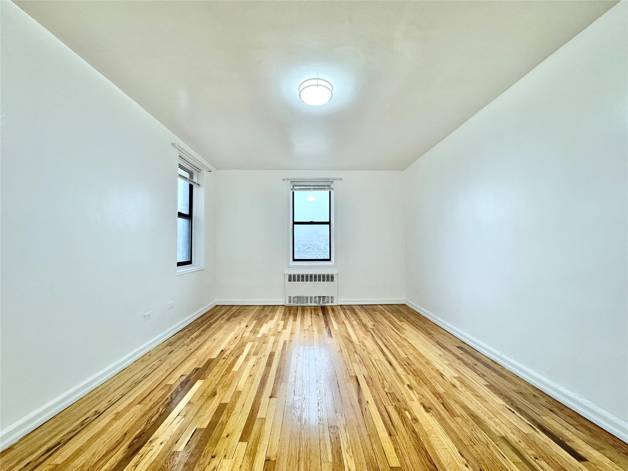84-19 51st Avenue, Unit 4E Queens, NY 11373 - Photo 6 of 7 a view of a room with wooden floor and window