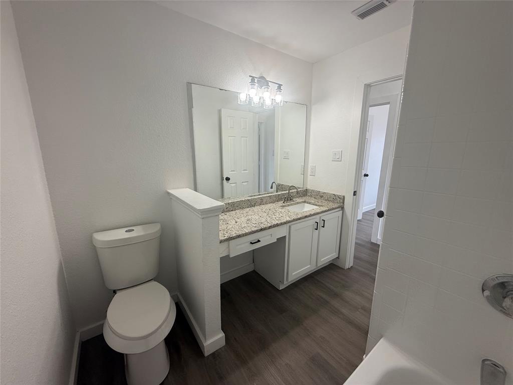 6005 Meadowdale Road Arlington, TX 76017 - Photo 12 of 20 a spacious bathroom with a toilet sink and a mirror