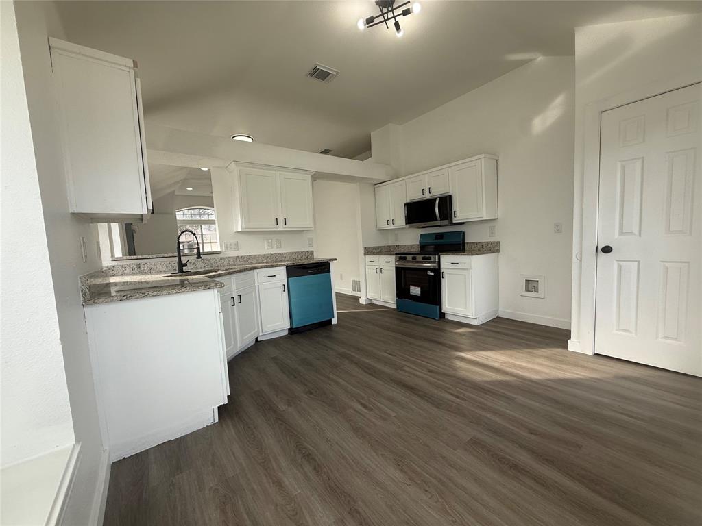 6005 Meadowdale Road Arlington, TX 76017 - Photo 6 of 20 a kitchen with granite countertop a stove top oven a sink dishwasher and a refrigerator with wooden floor
