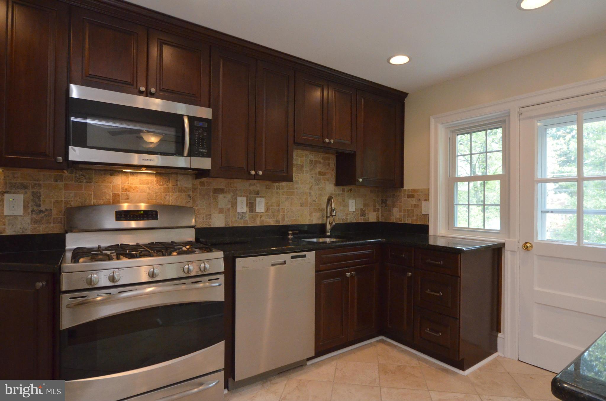 8649 Oak Road Baltimore, MD 21234 - Photo 7 of 30 a kitchen with granite countertop wooden cabinets and stainless steel appliances
