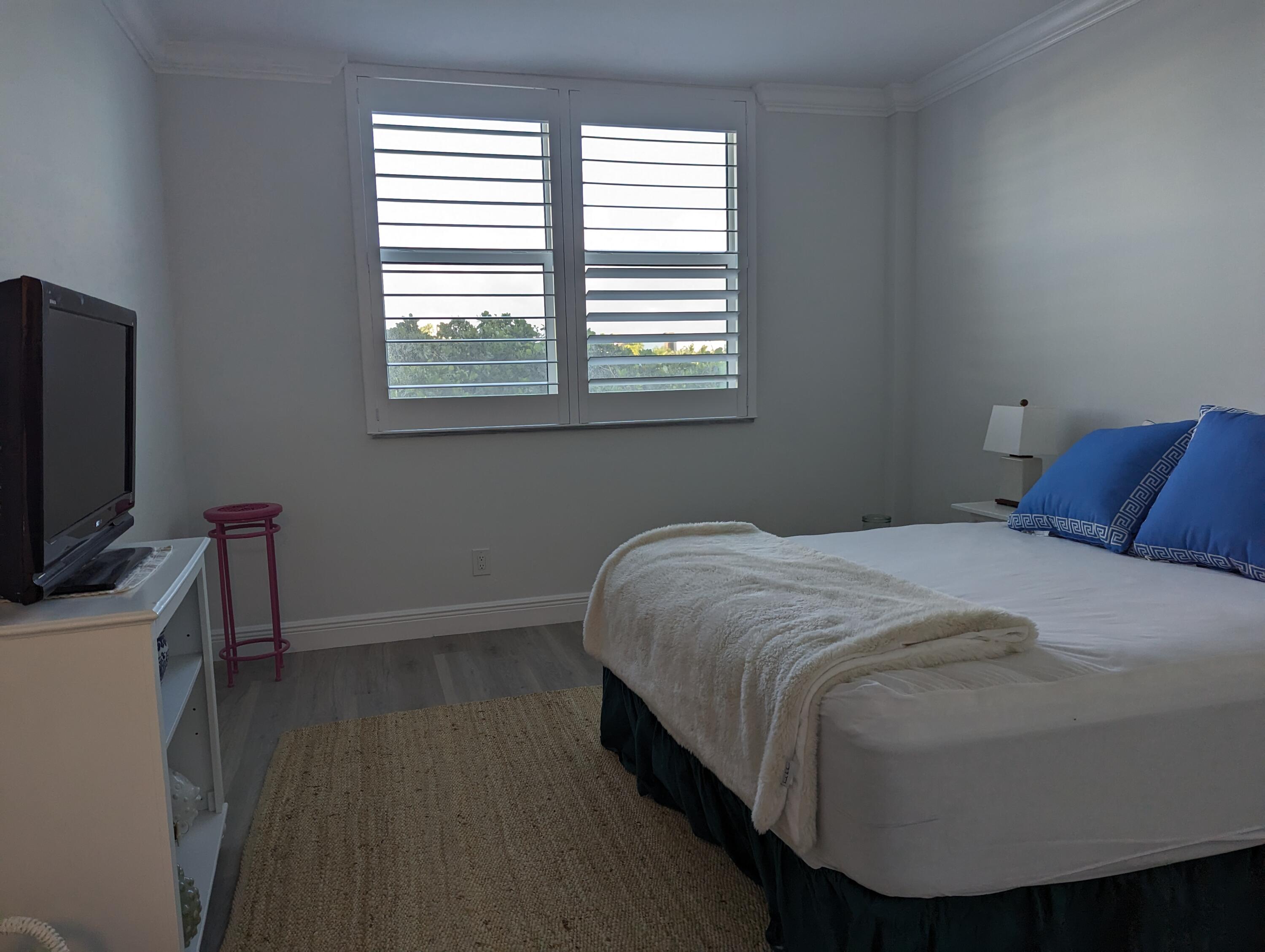 2840 South Ocean Boulevard, Unit 3230 Palm Beach, FL 33480 - Photo 11 of 18 a bedroom with a bed a flat screen tv and a window