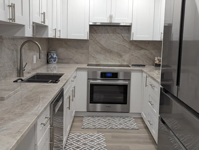 a kitchen with granite countertop a sink stove and cabinets