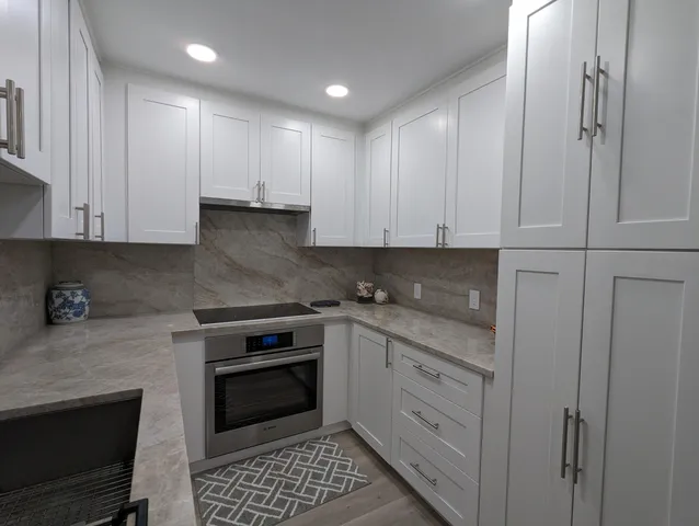 a kitchen with stainless steel appliances granite countertop a stove a sink and a refrigerator