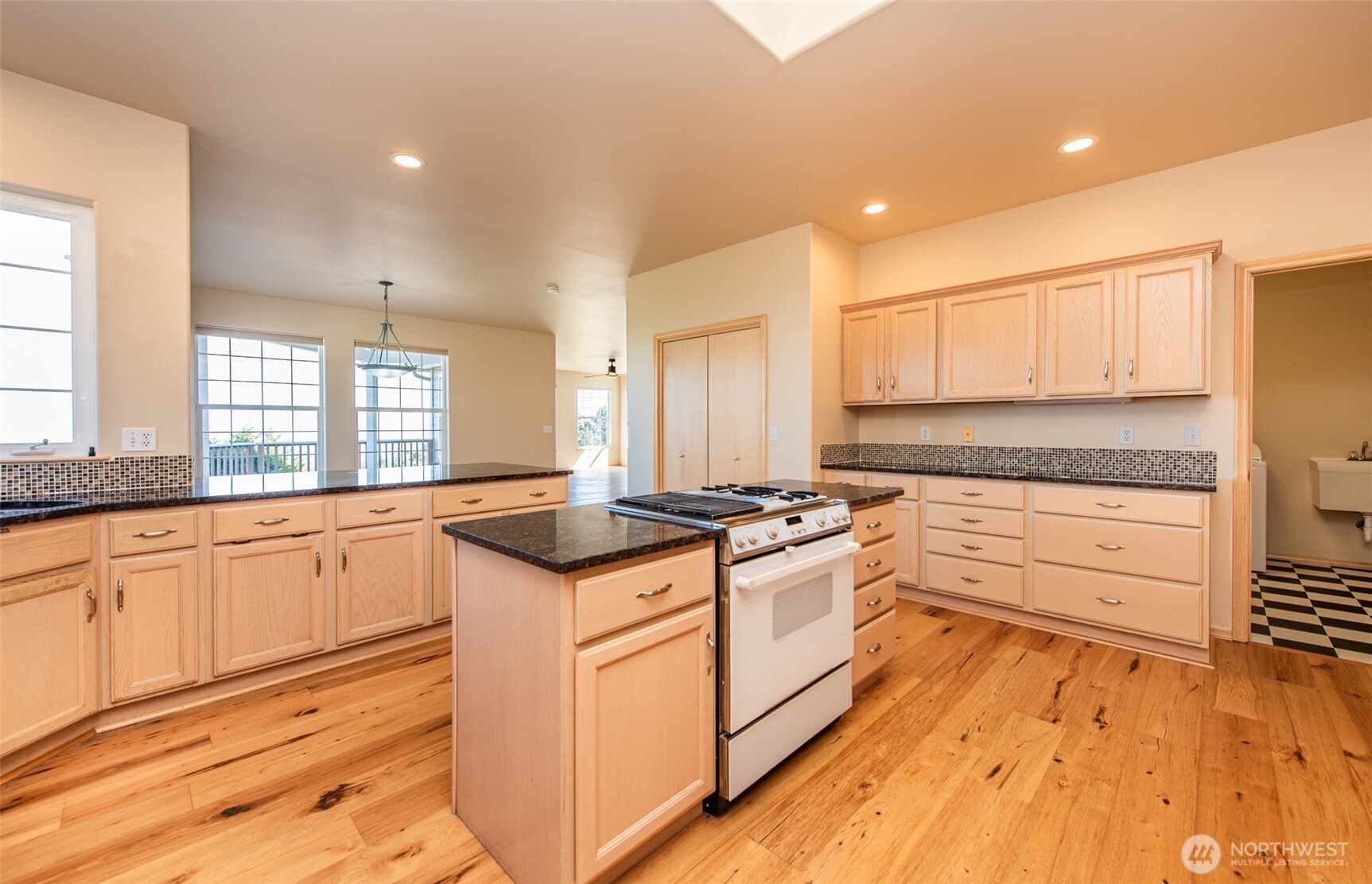 113 Quails Roost Road Sequim, WA 98382 - Photo 25 of 40 a kitchen with stainless steel appliances granite countertop a stove and white cabinets