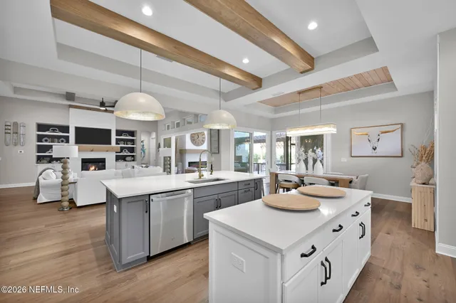 a kitchen with stainless steel appliances a dining table chairs and wooden floor
