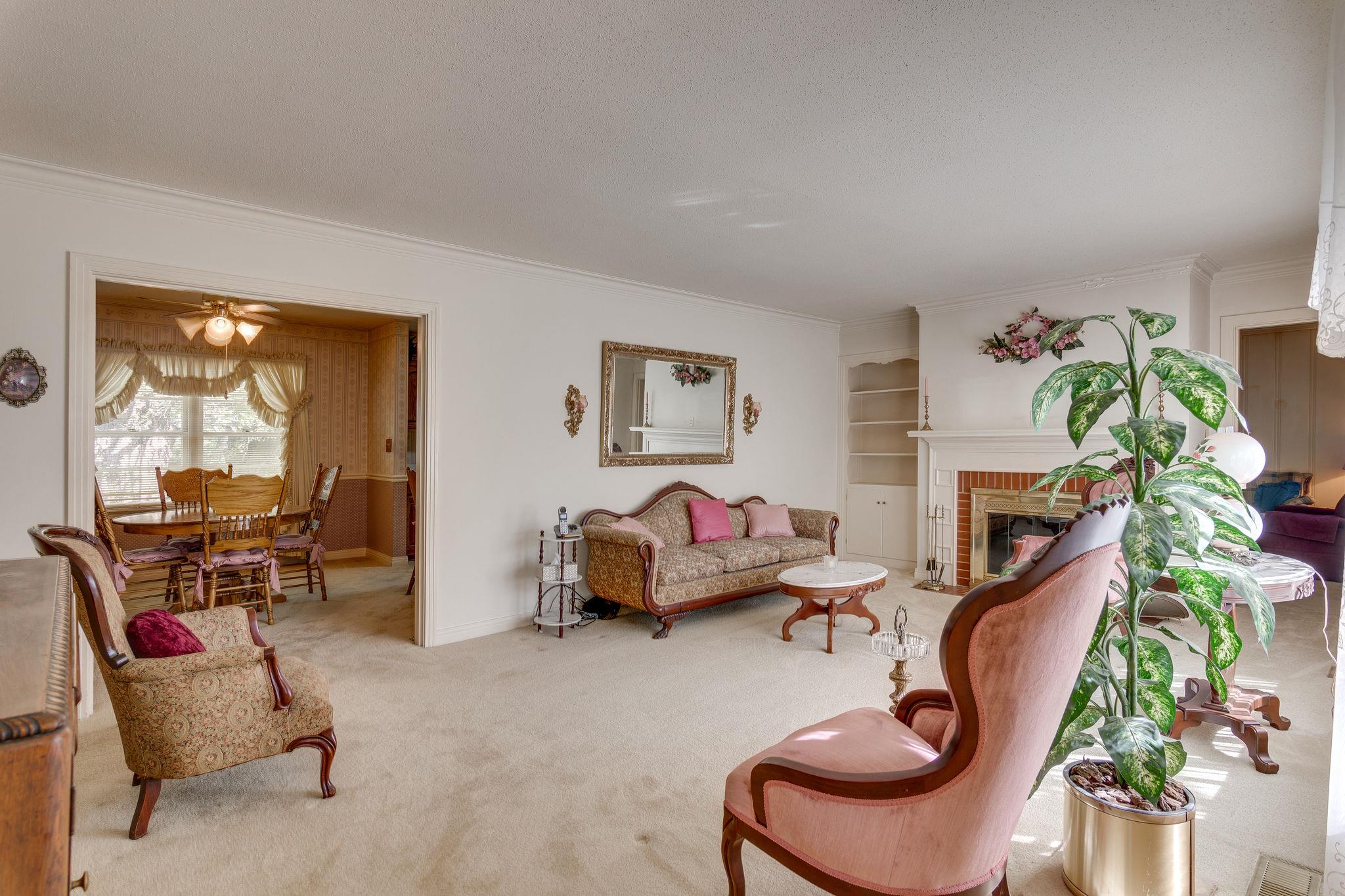 Spacious living room with fireplace & built -in book case...(hardwood floors under most carpet)..