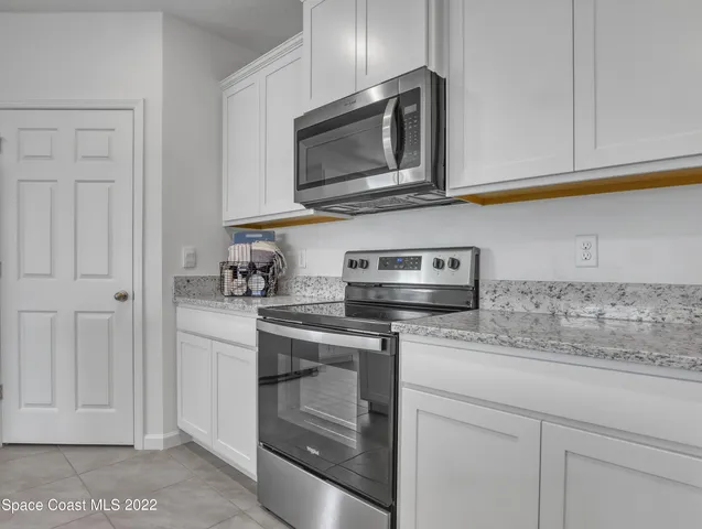 a kitchen with stainless steel appliances granite countertop white cabinets stove a sink and dishwasher