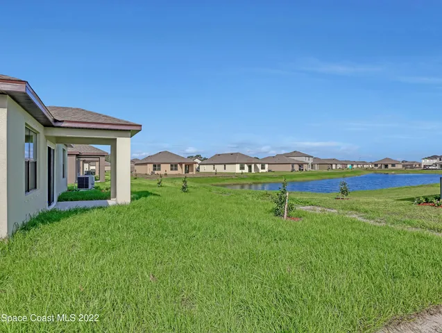 a house with green field in front of it