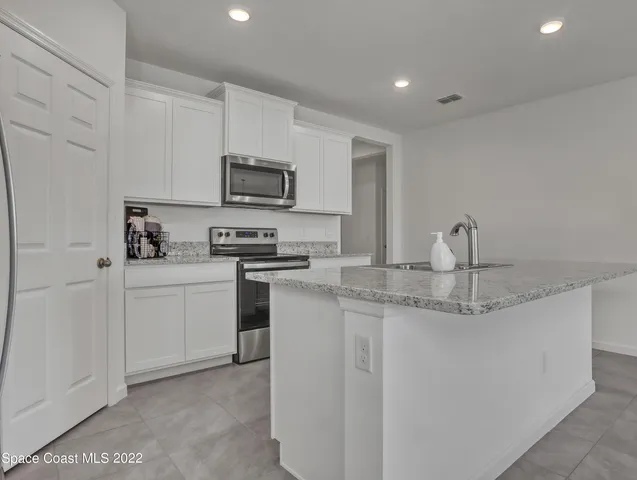 a kitchen with sink a microwave and cabinets