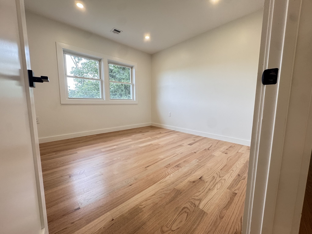 38 Middle Street Woburn, MA 01801 - Photo 11 of 39 a view of an empty room with wooden floor and a window
