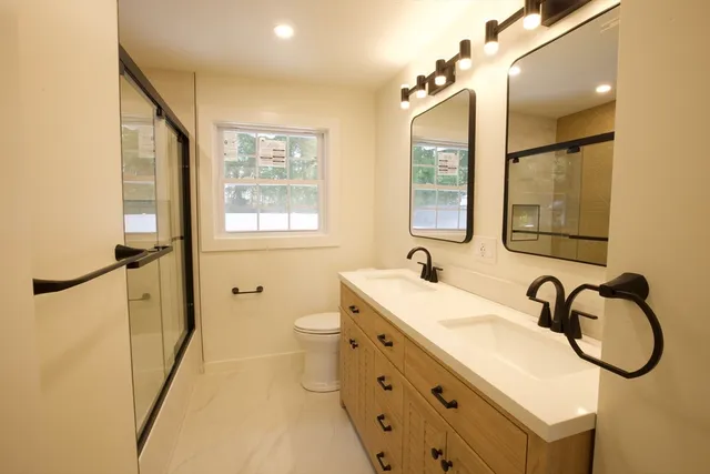 a bathroom with a granite countertop sink mirror vanity and a bathtub