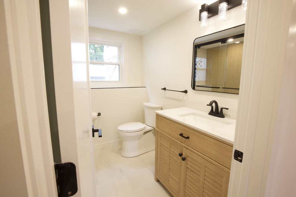 38 Middle Street Woburn, MA 01801 - Photo 21 of 39 a bathroom with a sink a toilet and a mirror