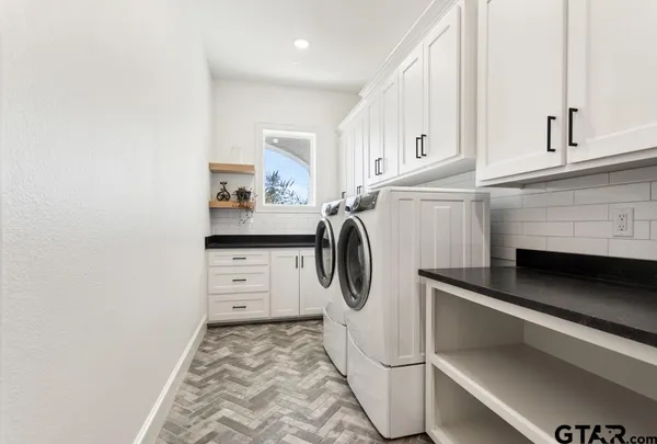 a utility room with cabinets washer and dryer