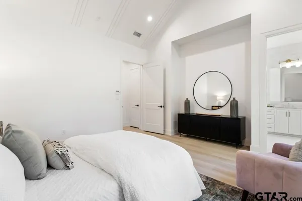 a bedroom with furniture and a mirror