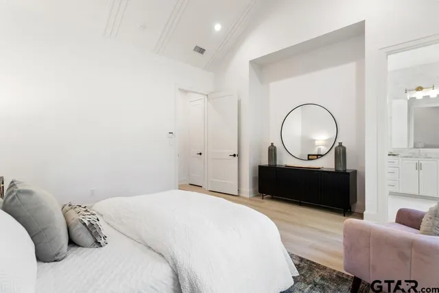 a bedroom with furniture and a mirror