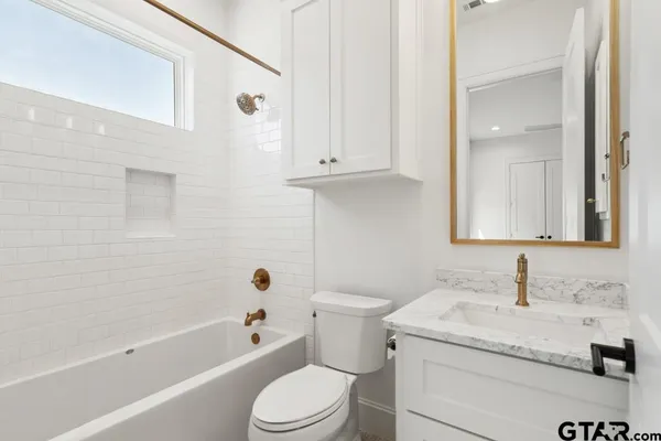 a bathroom with a granite countertop toilet a sink and bathtub